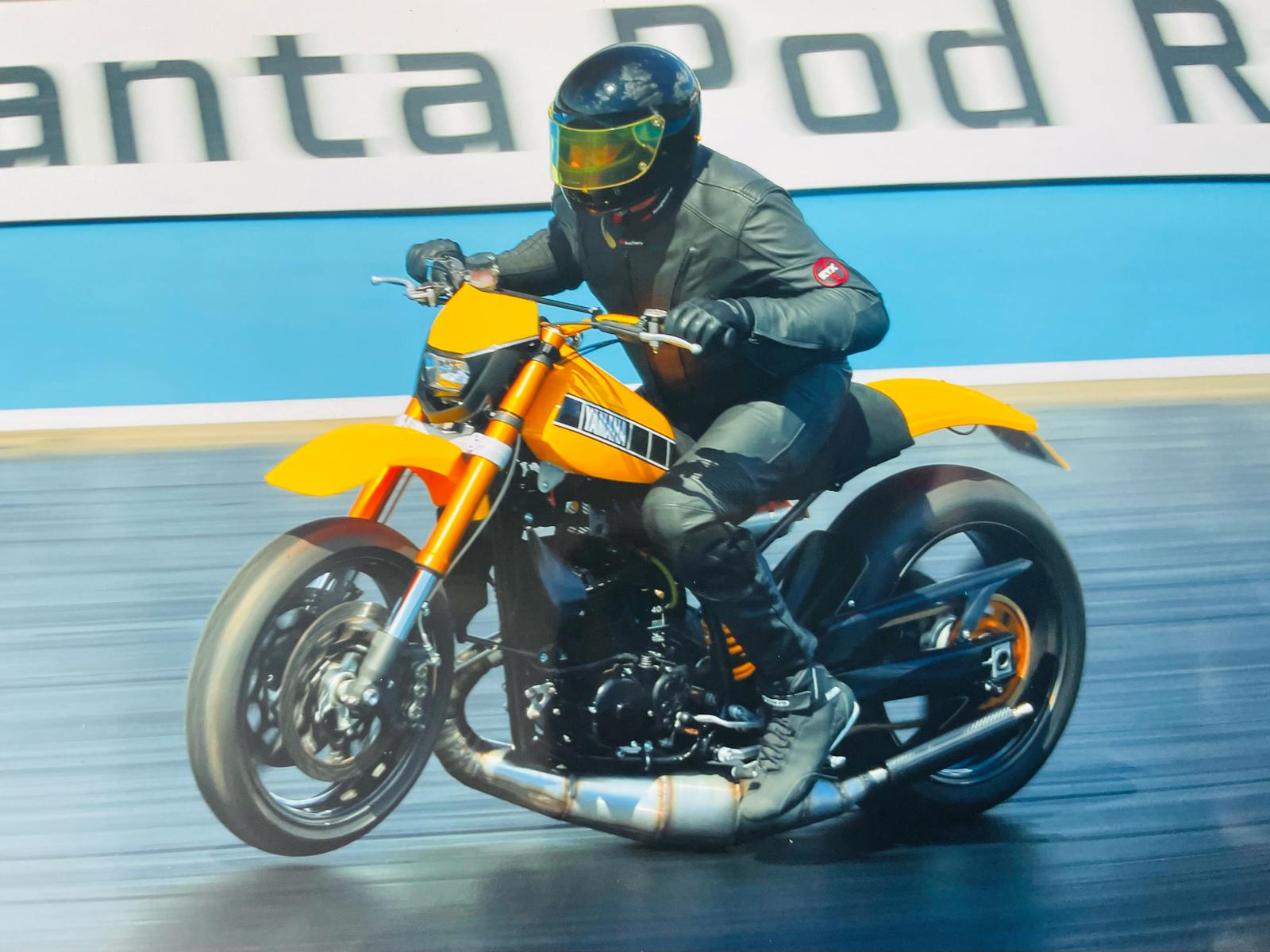 Person riding a yellow motorcycle on a track with a blurred background